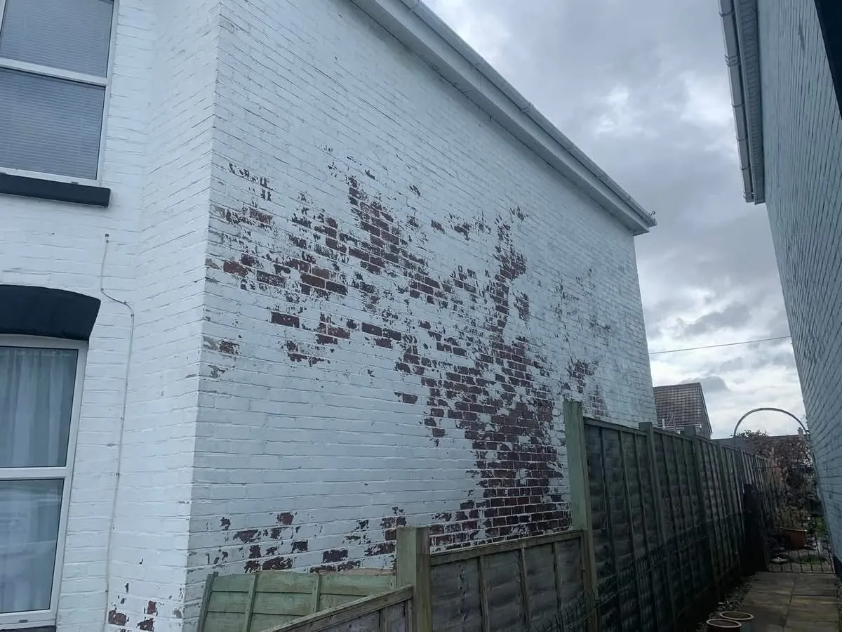 Peeling paint on a brick wall before redecoration in Budleigh Salterton